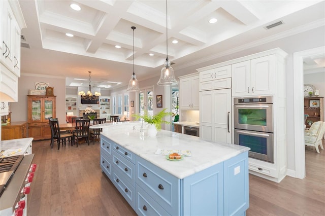 kitchen with visible vents, decorative light fixtures, wood finished floors, stainless steel double oven, and white cabinets