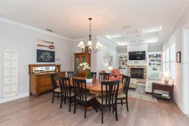 dining space featuring light wood finished floors, a brick fireplace, baseboards, ornamental molding, and coffered ceiling