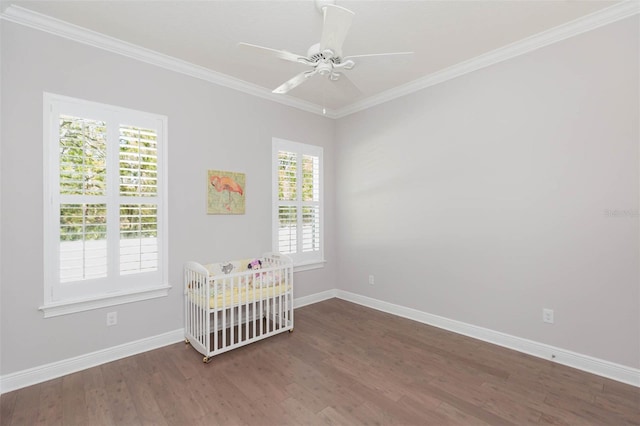 unfurnished bedroom featuring crown molding, wood finished floors, and baseboards