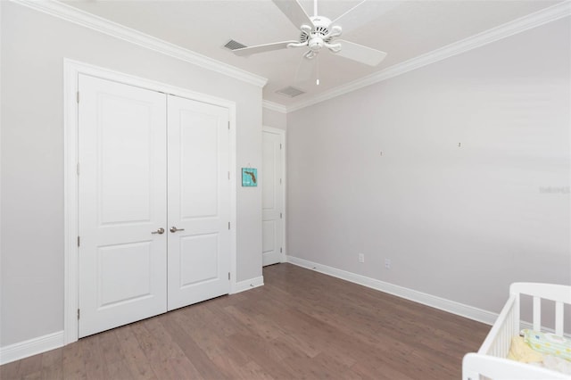 unfurnished bedroom featuring visible vents, baseboards, wood finished floors, and ornamental molding