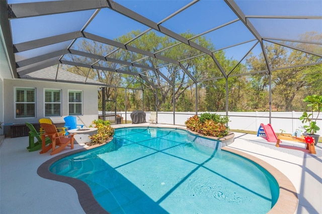 view of pool with glass enclosure, a patio, a fenced in pool, and fence