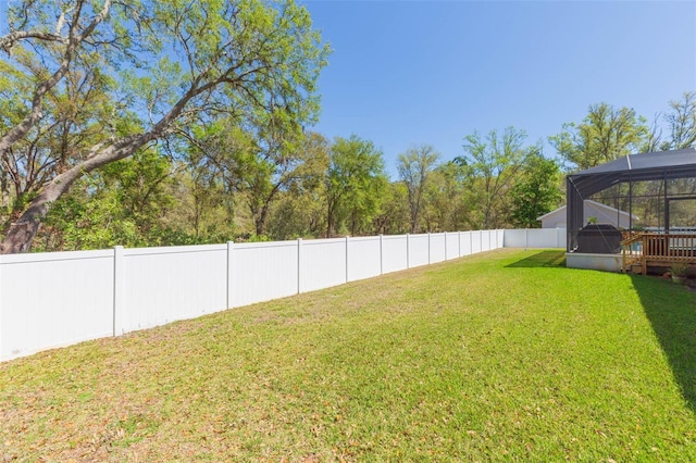 view of yard featuring glass enclosure and a fenced backyard