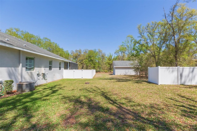 view of yard featuring central AC unit, an outdoor structure, and fence