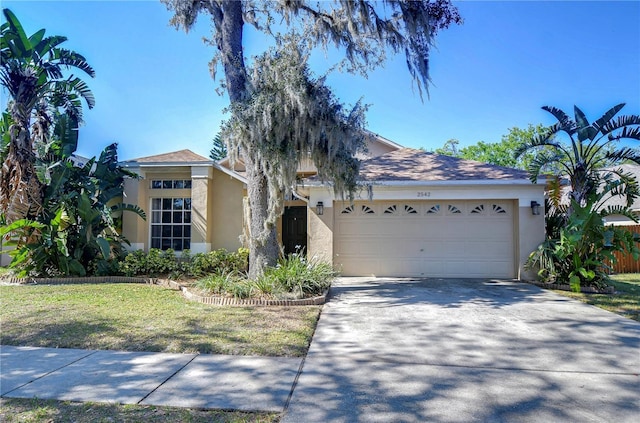 view of front facade featuring stucco siding, a garage, concrete driveway, and a front yard