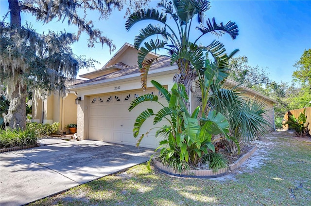 view of front of house featuring stucco siding, concrete driveway, and an attached garage