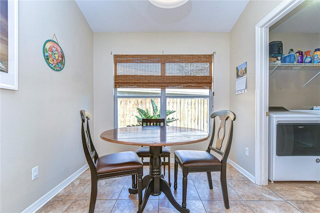 dining area featuring baseboards, washer / dryer, and light tile patterned flooring