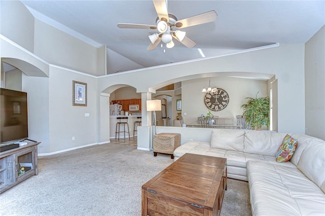 living room featuring carpet, baseboards, arched walkways, vaulted ceiling, and ceiling fan with notable chandelier