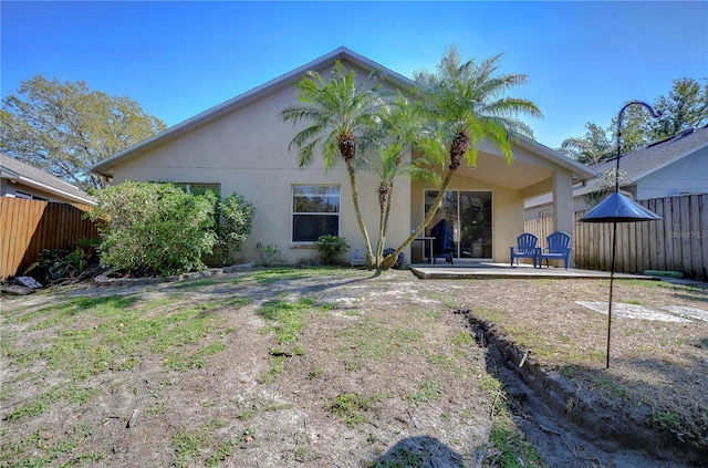 back of property with a patio area, stucco siding, and fence