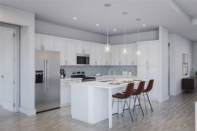 kitchen with backsplash, light countertops, an island with sink, appliances with stainless steel finishes, and a sink