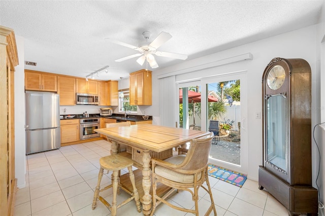 dining room featuring visible vents, a textured ceiling, light tile patterned flooring, and a ceiling fan