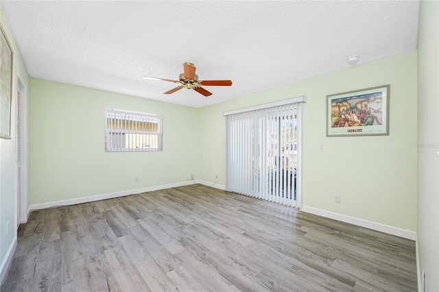 unfurnished room featuring baseboards, a textured ceiling, wood finished floors, and a ceiling fan