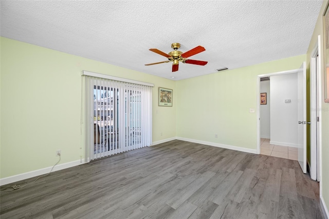 unfurnished room featuring wood finished floors, a textured ceiling, and ceiling fan