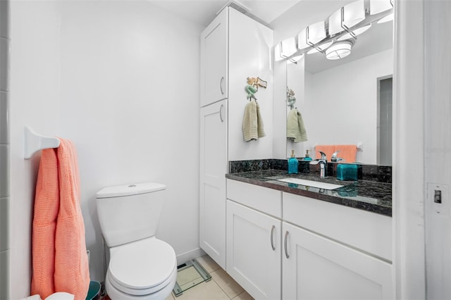 bathroom with tile patterned flooring, toilet, vanity, and baseboards