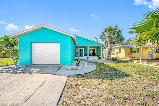 view of front of property with stucco siding, concrete driveway, a garage, and a sunroom