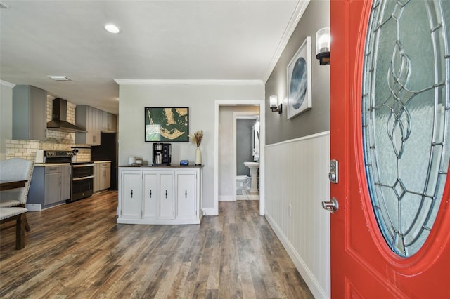 foyer entrance featuring dark wood finished floors, a wainscoted wall, and crown molding