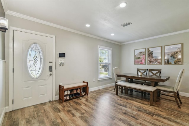 dining area featuring visible vents, ornamental molding, and wood finished floors