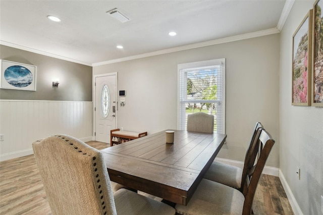 dining room with crown molding, visible vents, and light wood-type flooring