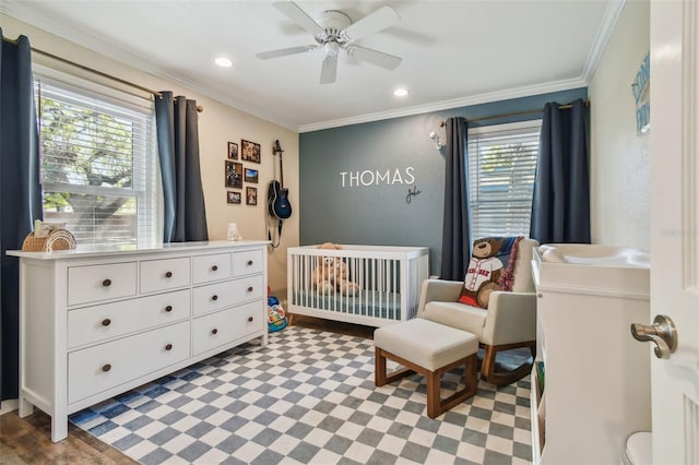 bedroom featuring a ceiling fan, recessed lighting, a nursery area, crown molding, and a textured wall