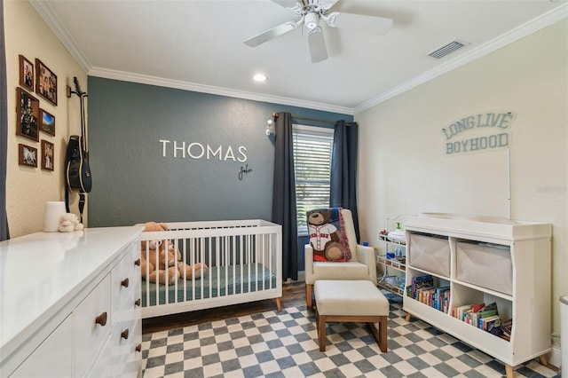 bedroom featuring visible vents, a nursery area, ceiling fan, and ornamental molding