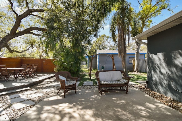 view of patio / terrace with an outbuilding, a fenced backyard, and outdoor dining space