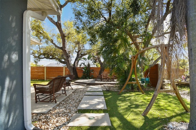 view of yard with a patio area, a playground, and a fenced backyard