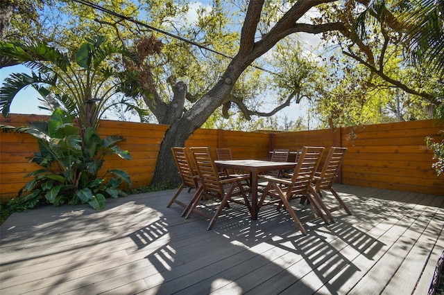 wooden terrace featuring a fenced backyard and outdoor dining space