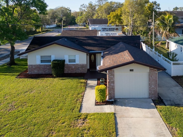 view of front of home featuring an attached garage, a front lawn, fence, stucco siding, and driveway