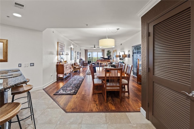 dining room featuring visible vents, crown molding, ceiling fan, and wood finished floors