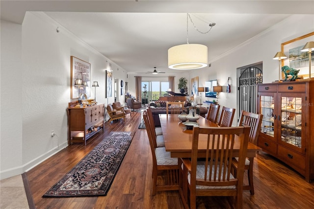 dining space featuring crown molding, wood finished floors, and baseboards