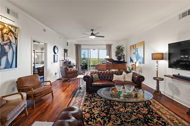 living room featuring visible vents, baseboards, wood finished floors, and crown molding