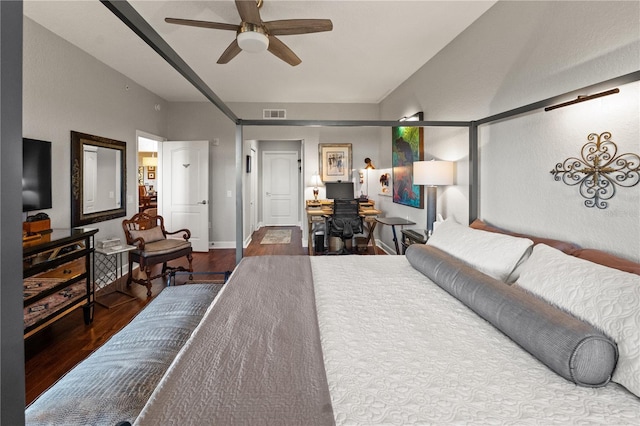 bedroom with a ceiling fan, wood finished floors, visible vents, baseboards, and vaulted ceiling