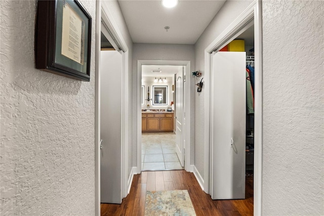 hallway with dark wood-style flooring and a textured wall