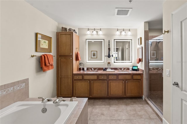 bathroom featuring tile patterned flooring, visible vents, a garden tub, a stall shower, and a sink