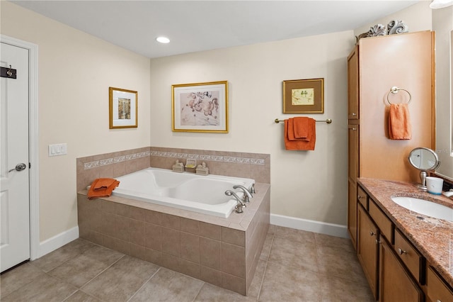 bathroom with tile patterned flooring, baseboards, vanity, and a garden tub