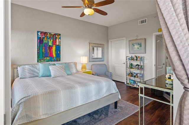 bedroom with a ceiling fan, wood finished floors, and visible vents