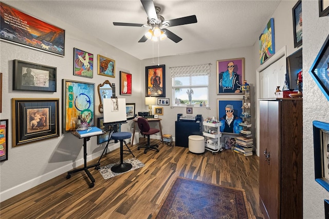 home office with a textured ceiling, baseboards, and wood finished floors