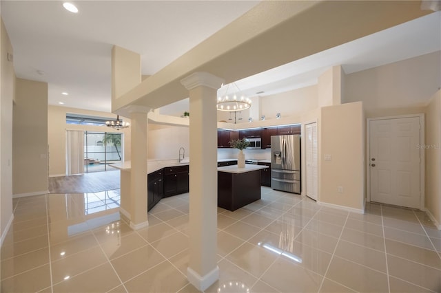 kitchen with appliances with stainless steel finishes, a chandelier, light tile patterned flooring, and light countertops