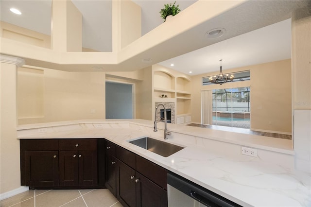 kitchen with a sink, built in features, stainless steel dishwasher, light tile patterned flooring, and light stone countertops