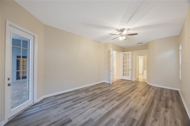 unfurnished room featuring wood finished floors, baseboards, and ceiling fan