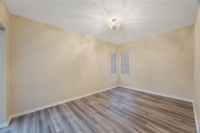 empty room featuring baseboards and wood finished floors