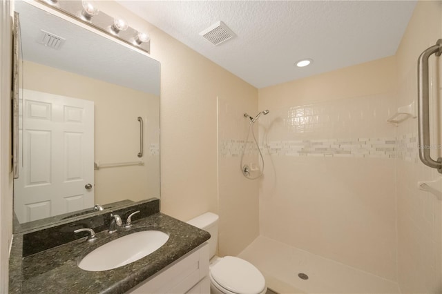 full bathroom featuring vanity, toilet, a shower, and visible vents