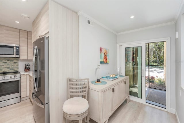 kitchen with visible vents, light wood-style flooring, stainless steel appliances, light countertops, and tasteful backsplash