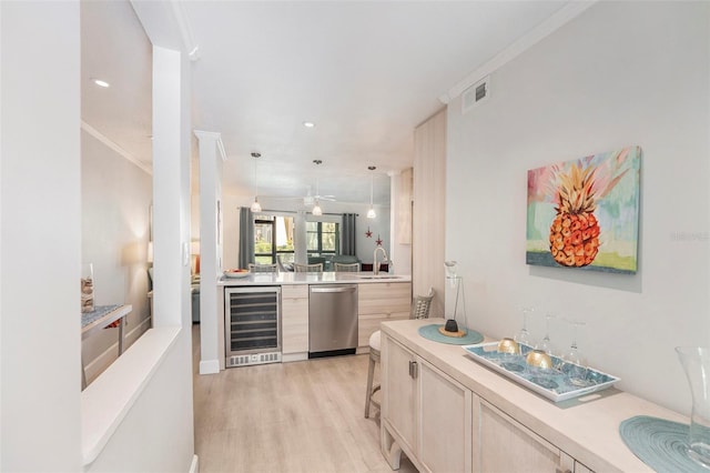 kitchen featuring visible vents, beverage cooler, light countertops, stainless steel dishwasher, and a sink