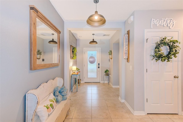 foyer entrance featuring light tile patterned flooring and baseboards