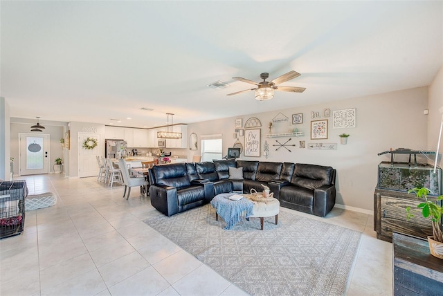 living area featuring light tile patterned floors, visible vents, and ceiling fan