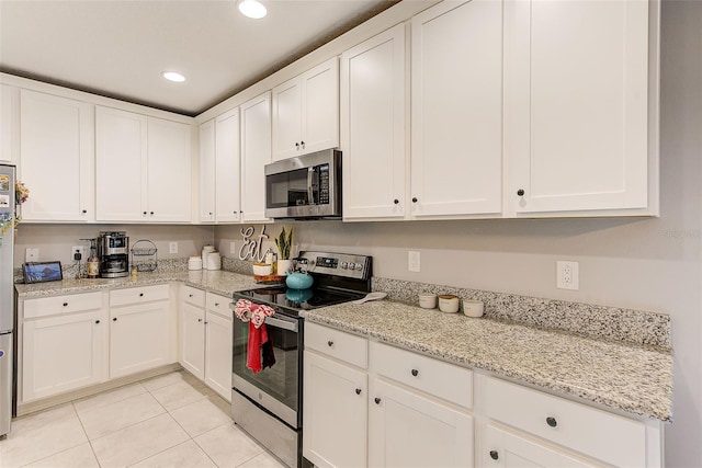 kitchen featuring light stone countertops, light tile patterned floors, recessed lighting, appliances with stainless steel finishes, and white cabinetry