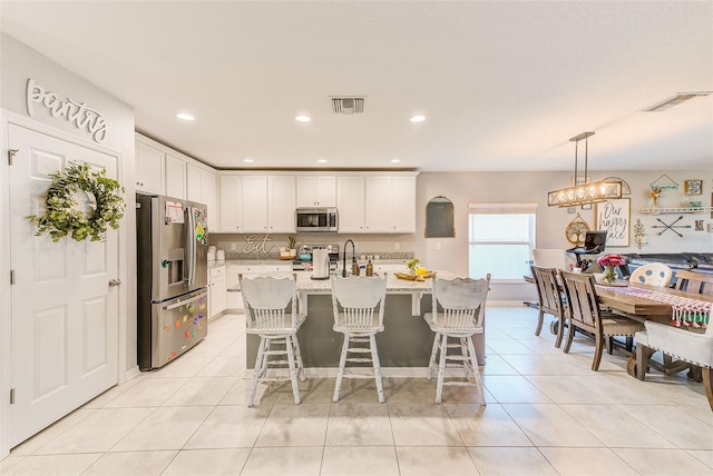 kitchen with white cabinets, light tile patterned floors, visible vents, and appliances with stainless steel finishes