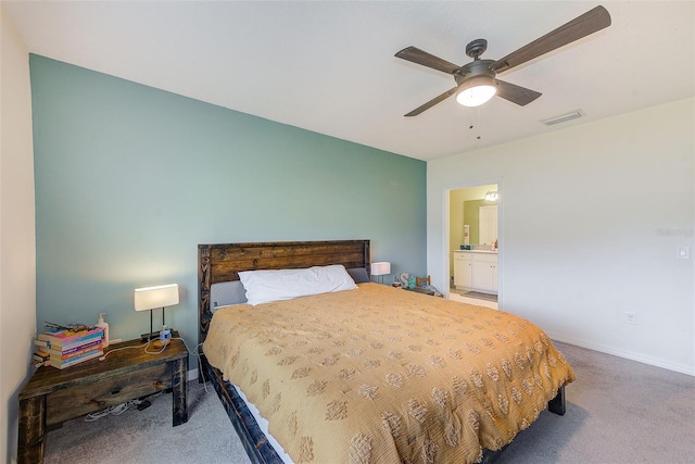 carpeted bedroom with visible vents, baseboards, connected bathroom, and a ceiling fan