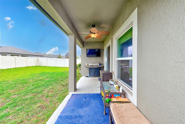 view of patio with a ceiling fan, fence, and grilling area