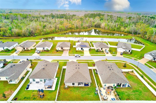 birds eye view of property featuring a residential view, a wooded view, and a water view